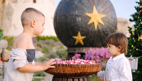 Two boys offering flowers on Christmas.