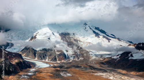 Photos Glacial valley floor beneath a cloud-wrapped peak