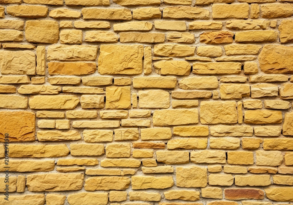 Fototapeta premium Textured Yellow Stone Brick Wall Background Pattern.