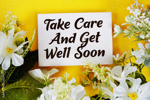 Canvas Print Take Care And Get Well Soon text written on paper card with flowers decoration o