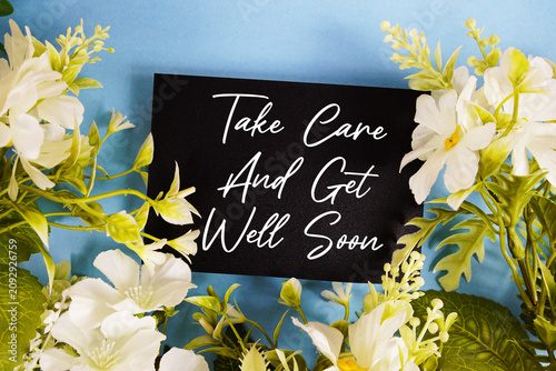 Canvas Print Take Care And Get Well Soon text written on paper card with flowers decoration o