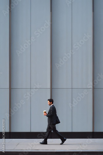 Businessman walking on the sidewalk.