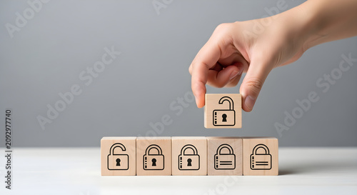 Hand placing a wooden block with an unlocked padlock symbol to solve data security and cybersecurity access challenges