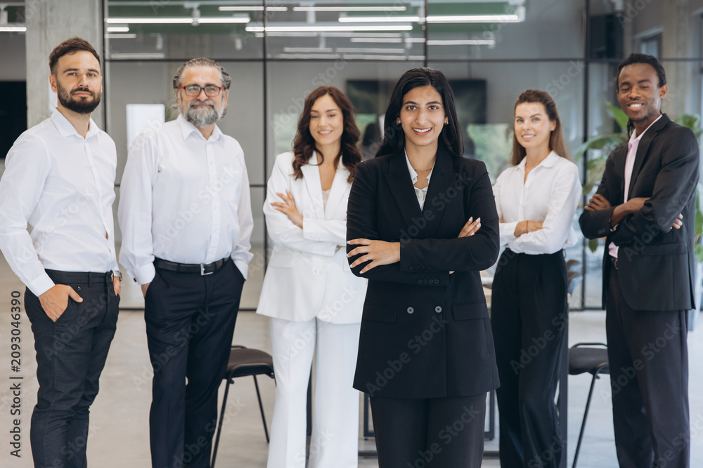 Obraz premium Confident business professionals standing together, diverse executive team inspiring teamwork and celebrating successful careers