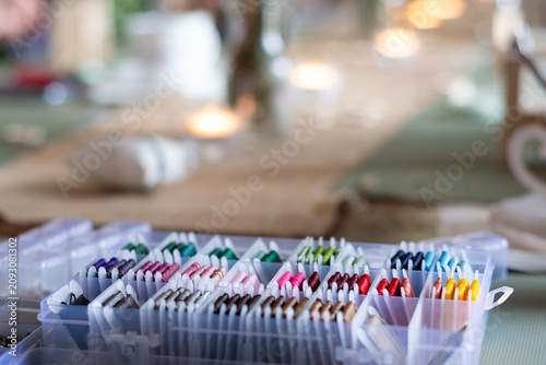 фотографія Colorful embroidery thread spools organized in plastic storage box, soft blurred