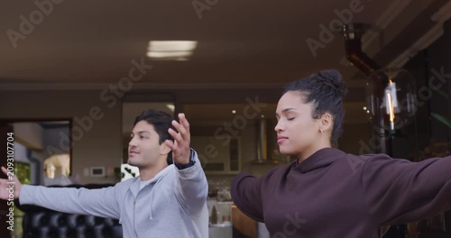 African American couple meditating, raising arms from sides to prayer for calm at home smartwatch