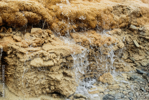 Foto Flowing mineral spring over travertine formations
