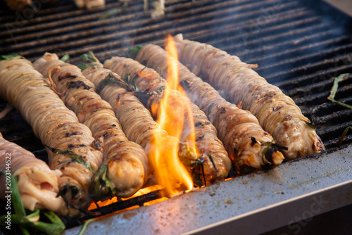 Fényképezés Close-up of traditional Sicilian stigghiola in Ballaro Market in Palermo, a grilled street food delicacy made of lamb intestines wrapped around scallions