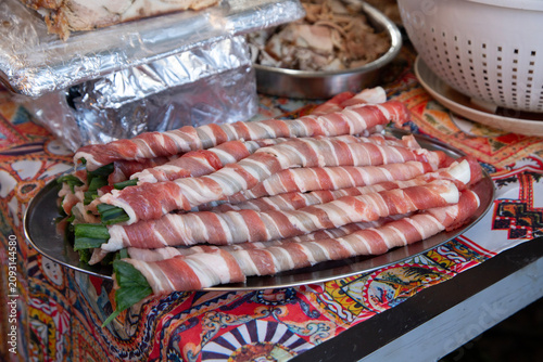 Obraz na plátně Close-up of traditional Sicilian stigghiola in Ballaro Market in Palermo, a grilled street food delicacy made of lamb intestines wrapped around scallions