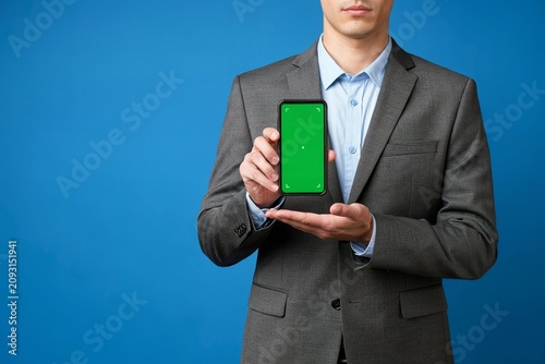 Businessman Holding Smartphone With Green Screen Mockup and Copy Space