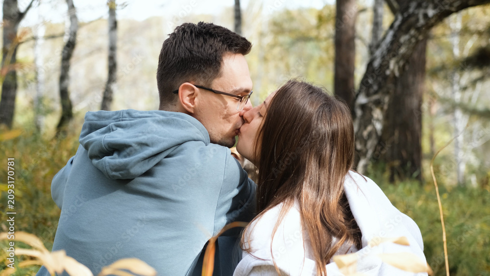 Fototapeta premium kissing, in forest, with trees, leaves, with clothing, hair texture, from a close-up perspective, with blue, white accents, and mood, with clear.