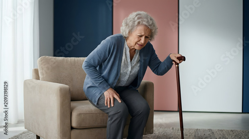Senior woman with cane struggling to stand up