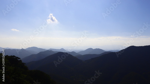 Tableau sur toile Hazy Layered Mountain Range with Atmospheric Perspective Under a Blue Sky
