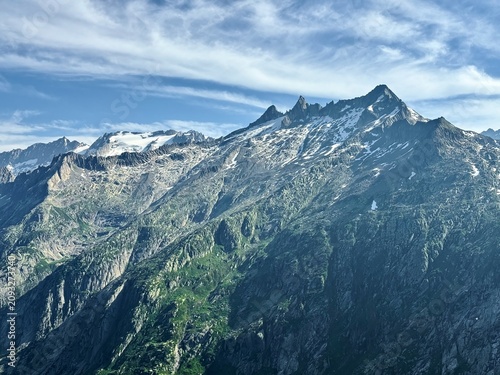 Obraz na plátně Rugged glaciated granite peak with lingering snow and a small glacier