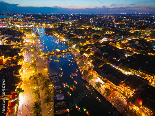 Panorama aerial drone view of Hoi An ancient town with boat tour and beautiful lanterns in sunset. UNESCO world heritage. One of the most travel popular touristic destinations

