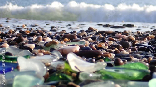 Sea glass, Green pieces of glass polished by the sea closeup background. A pile of natural beach glass, Multi colored pieces of polished glass. Color. Beach pebbles and shells in the Mediterranean sea