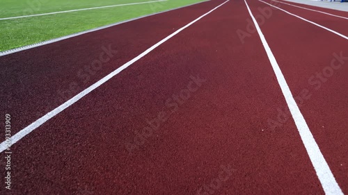 Rubber running track features paint lines dividing training lanes. Close texture view shows empty athletic surface ready for competition