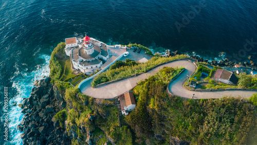 Konstfotografi Farol do arnel lighthouse on a winding coastal road at dusk