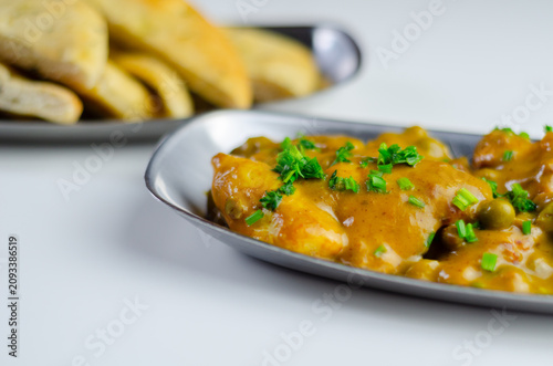 Warm curry dish with peas and herbs garnish