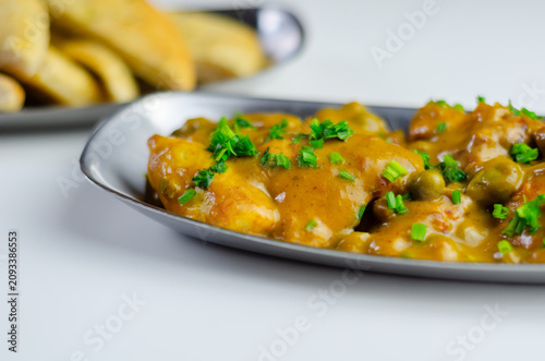 Warm curry dish with peas and herbs garnish