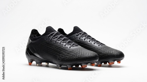 Pair of modern black soccer cleats on white background, professional athletic football boots, sleek studio product shot.