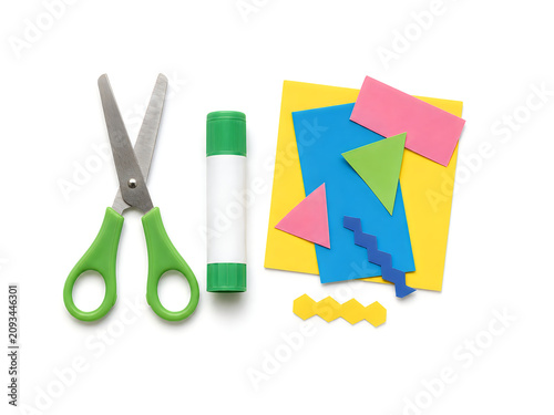 School scissors and glue stick. Craft supplies with colorful paper shapes. Creative art project kit.