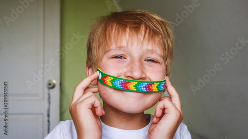 A boy holding a diamond mosaic bracelet craft close-up