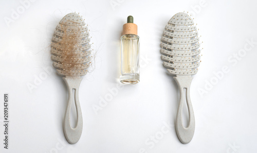Quadro su tela Hair serum dropper bottle placed between a hairbrush with shed hair and a clean hairbrush