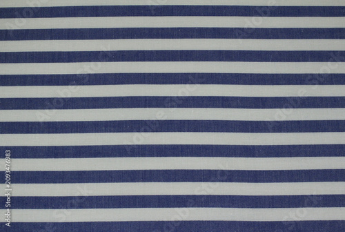 Texture of classic blue striped cotton cloth background. Close up of blue and white horizontal striped fabric.