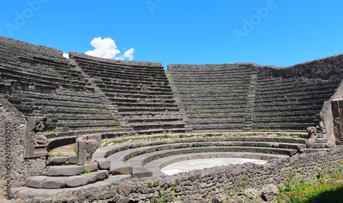 Foto Ancient Roman Amphitheater Ruins in Pompeii Archaeological Park under Bright Blu