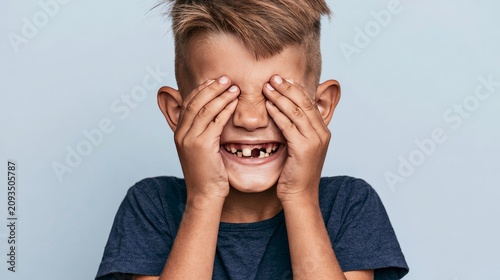 Young boy with joyful expression showing missing teeth, capturing childhood innocence, happiness and playful spirit with a cute smile during a natural growing stage