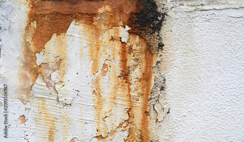 Rust stains and peeling paint on an old weathered concrete wall texture.