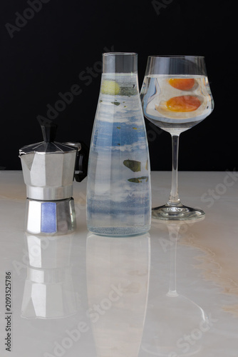 Foto coffee maker, glass bottle, and glass on a marble table