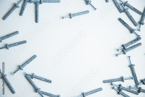 A top view of the self-tapping screws with dopes, which lie on the sides on a white background with free space in the center for text. The concept of repair, screwing, fixing, construction. High
