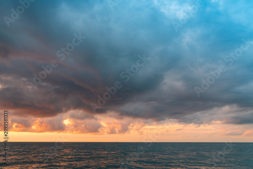 Sunset over the sea after rain with thunder clouds. Sky background.