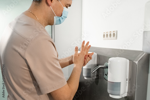 Surgeon washes hands with attention to hygiene and safety protocols in clinic. Infection control starts with effective cleansing practices