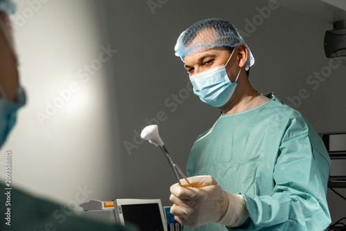 Fotografie Man surgeon holds sterile cotton swab in operating room