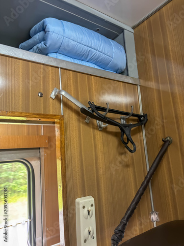 Canvastavla Train compartment showing blue blanket in storage and coat hangers on wooden pan