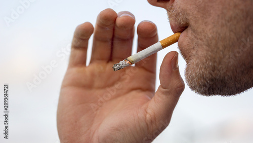 Cuadro en lienzo close up of a man smoking a cigarette on a blurred background with copy space fo