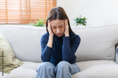 Canvastavla Young woman feeling headache sitting on sofa.