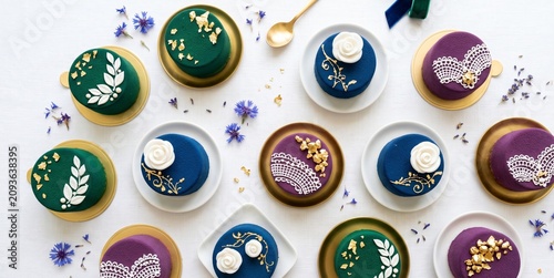 Elegant miniature mousse cakes decorated with gold leaf and fondant flowers