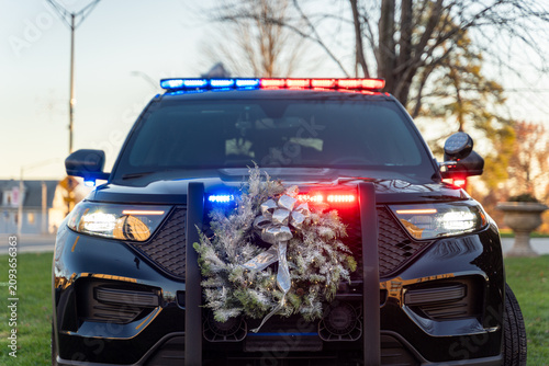 Bild auf Leinwand Eye level close up view of a police cruiser decorated with a Christmas wreath an