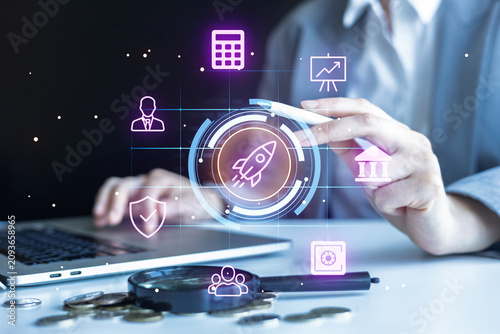 Business person using technology for financial growth with graphics and laptop in workspace