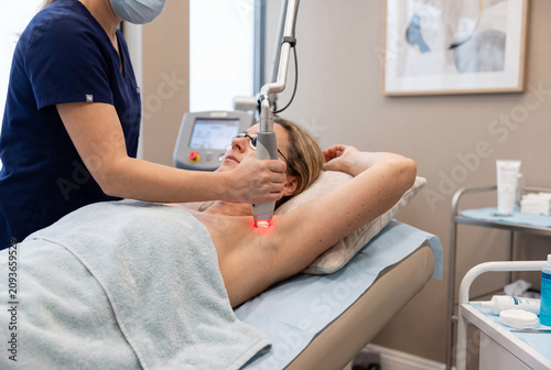 Woman receiving laser hair removal armpit treatment