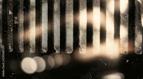 Closeup of a dirty old metal grate with light shining through the rusty mesh screen  industrial background texture