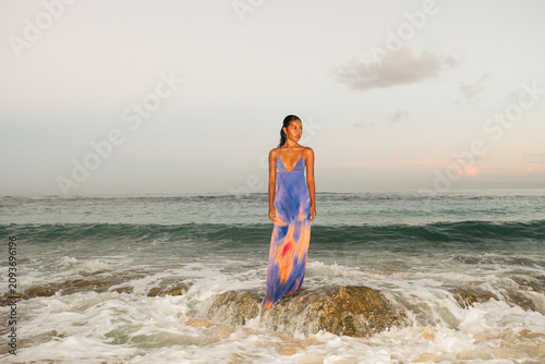 Woman Standing on Rock in Ocean Waves