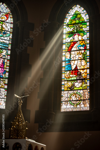 Sunlight Streaming Through Stained Glass Window Inside Historic Church