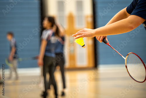 Badminton Player Serving Shuttlecock During Indoor Match