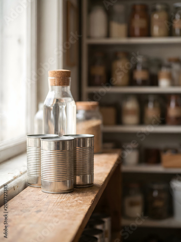 Close-up of Stacked Canned Food and Water Bottle on Wooden Pantry Shelf