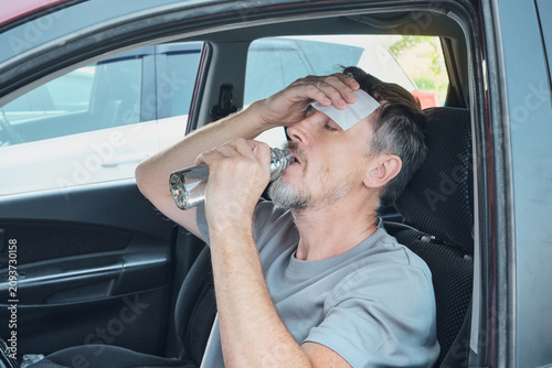 Fotografía Man feeling sick from heat, drinking water and cooling forehead with cold compre